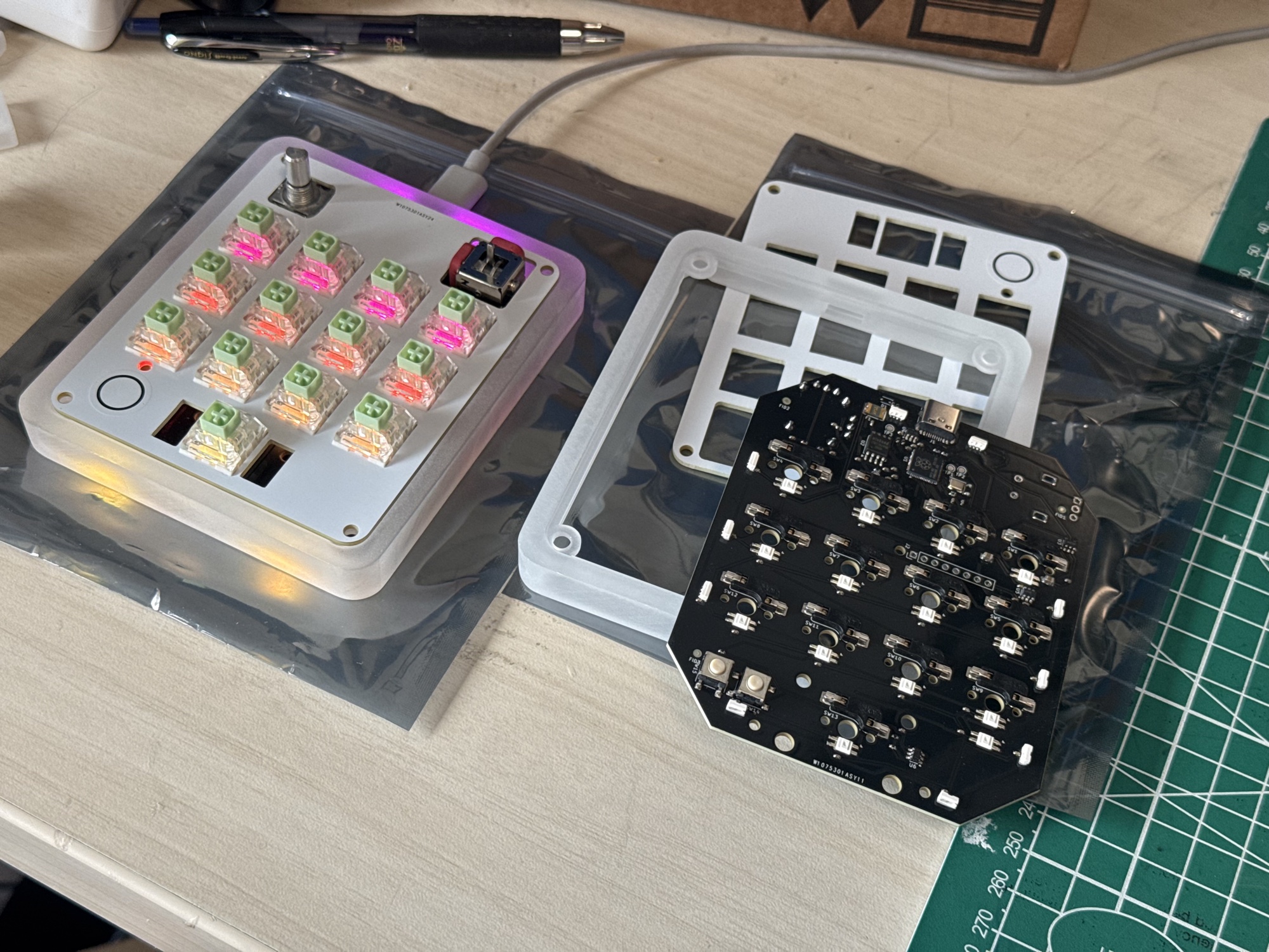 AgentPad13 beside its exposed PCB, frosted case, and top plate during test fitting.